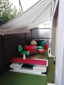 Zimmer mit 2 Stühlen und einem Bett unter einem Zelt in der Unterkunft Joli Appartement Coquet in Reims