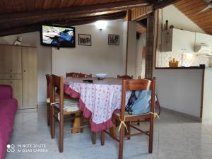 mesa de comedor con sillas y TV en Casa Rosa, en Capitello