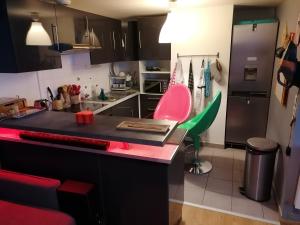 a kitchen with a counter and a pink chair at Joli Appartement Coquet in Reims