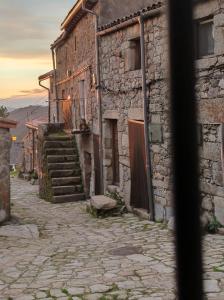 un callejón en un antiguo edificio de piedra con escaleras en La Lagareta de Olivia en Trevejo