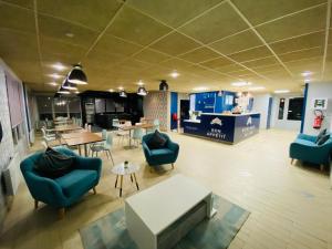 a living room with blue chairs and a table at Hotel RBX - Roubaix Centre in Roubaix