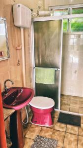 Suíte Rústica في فلوريانوبوليس: حمام به مرحاض احمر ومغسلة