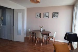 uma sala de jantar com mesa e cadeiras em appartement 70m² 3 chambres avec 3 lits 2 places em Troyes