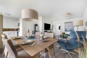 een eetkamer en een keuken met een tafel en stoelen bij Pierstern 53 in Olpenitz