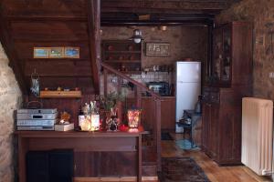 a kitchen with a table and a refrigerator at Lithia s Stonehouse. Το πέτρινο στη Λιθιά - Καστοριά in Lithiá