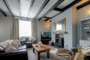 a living room with a couch and a tv at Mole Cottage in Frosterley
