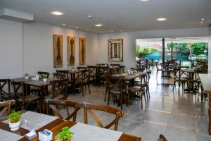 a restaurant with tables and chairs in a room at Castelo Inn Hotel in Goiânia