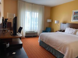 a hotel room with a bed and a desk with a television at Baymont by Wyndham Chambersburg in Chambersburg +39 photos