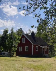 a red house with a picnic table in a field at Stora Mo in Tving