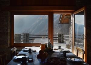a dining room table with a view of a mountain at LA MURA’ - Il vostro posto nel Gran Paradiso in Ronco Canavese