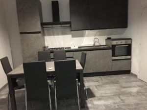 una cucina con tavolo, sedie e fornelli di Pierpa's House o Casa Pierpa a Catania Altre 13 foto