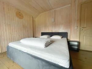 ein Schlafzimmer mit einem Bett in einer Holzwand in der Unterkunft Guest House Lviv in Lwiw