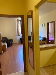 ein Wohnzimmer mit gelben Wänden und einem Spiegel in der Unterkunft Flora Apartment 613 in Borowez