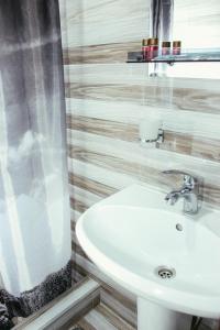Un baño con un lavabo blanco y un espejo. en Apartment Izabella, en Tiflis 21 fotos más