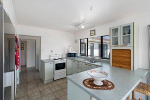 A kitchen or kitchenette at Hit The Beach - Waitarere Beach Holiday Home