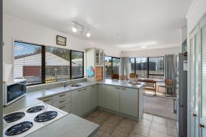 A kitchen or kitchenette at Hit The Beach - Waitarere Beach Holiday Home