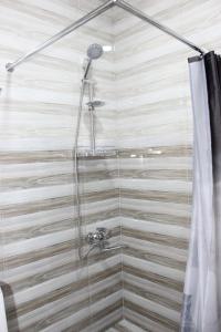 una ducha en un baño con cortina de ducha en Apartment Izabella, en Tiflis