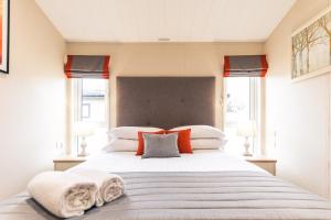 a bedroom with a large bed with towels on it at Heathery Lodge with Hot Tub in York