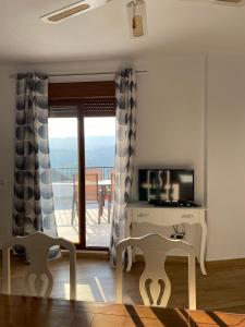 a living room with a television and a balcony at Casa con vistas 2 in Frigiliana