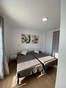 a bedroom with a bed and two paintings on the wall at Casa con vistas 2 in Frigiliana