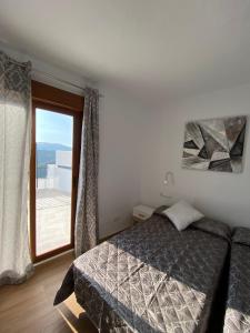 een slaapkamer met een bed en een groot raam bij Casa con vistas 2 in Frigiliana