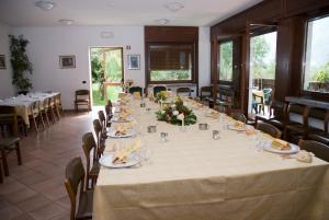 a long table in a room with tables and chairs at Hotel Ristorante Sassi Rossi in Taceno