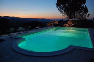 モンテファルコにあるVilla with Pool and Countryside Viewの夕日を背景に見えるスイミングプール