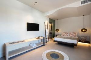 a bedroom with a bed and a tv on a wall at Parion Opus in Naousa