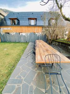 una mesa de madera y una silla frente a una casa en Les Granges de Clarabide, en Loudenvielle