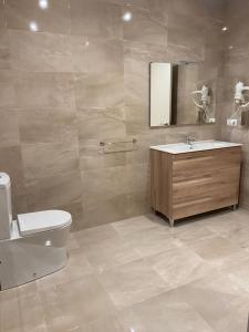 ein Badezimmer mit Waschbecken, Toilette und Spiegel in der Unterkunft Tu&Mi Villafranca in Villafranca del Bierzo + 19 Fotos