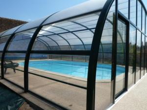 a swimming pool with a glass roof with a swimming pool at Gîtes du Martroy in Nargis