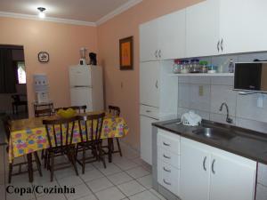 a kitchen with a table and a dining room at Pedacinho do Toque in São Miguel dos Milagres