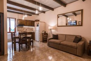 uma sala de estar com um sofá e uma sala de jantar em Miguel House em Alghero