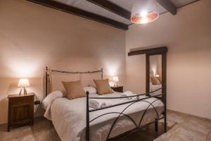 um quarto com uma cama e duas mesas e dois candeeiros em Miguel House em Alghero