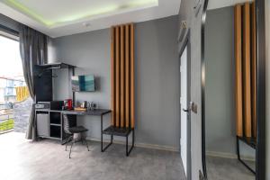 a room with a desk and a computer on a wall at Melanj Airport Hotel in Arnavutköy