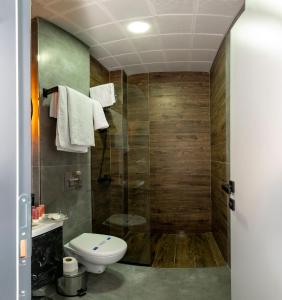 a bathroom with a toilet a sink and a shower at Melanj Airport Hotel in Arnavutköy
