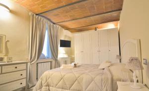 Un dormitorio con una gran cama blanca y una ventana en Borgo in Città, en Pistoia