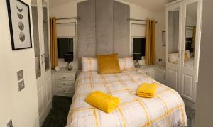 Un dormitorio con una cama con almohadas amarillas. en The Lunar Ray, en Felton