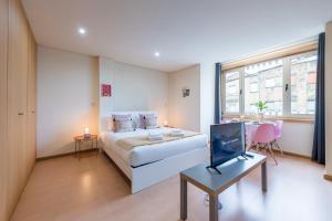 a bedroom with a bed and a tv and a table at GuestReady - MusicHall in Porto +20 photos