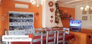 a dining room with orange walls and a table and chairs at Casa Genny in Nettuno
