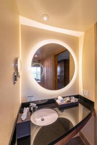 La salle de bains est pourvue d'un lavabo et d'un miroir. dans l'établissement Miyako Hybrid Hotel Torrance, à Torrance