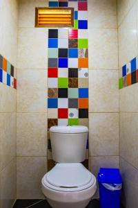a bathroom with a toilet with colorful tiles on the wall at Riverside Ecoliving Space in Jericó