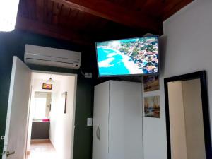 TV de pantalla plana en la pared de una habitación en La Posadita Familiar en Yerba Buena