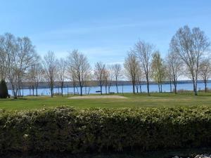 un campo de golf con árboles y agua al fondo en Chalet memphrémagog - 203, en Magog-Orford