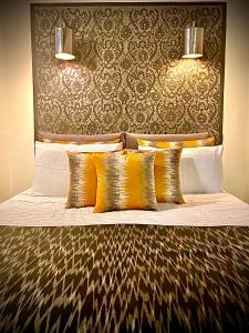 uma cama com almofadas douradas e uma cabeceira em La Maison Maure em Fez
