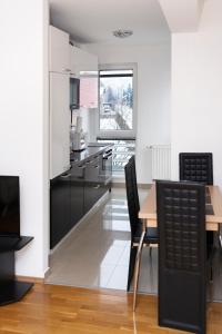 uma cozinha com armários pretos e uma mesa e cadeiras em Apartment Heaven em Sarajevo