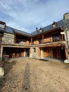 an exterior view of a large house with a yard at Gite le Tilleul in Avajan