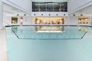 - une piscine avec un sol en verre dans un bâtiment dans l'établissement Diamond Beach Condos, à Galveston