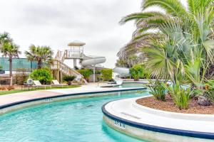 een zwembad met palmbomen op de achtergrond bij Diamond Beach Condos in Galveston
