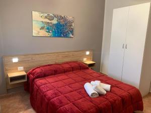 una camera da letto con un letto rosso con due asciugamani sopra di La Corte di Sofia a Realmonte